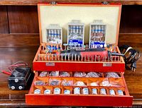 Full view of wooden chest containing Jobmate rotary tool with numerous bits and accessories, open drawers with containers of additional attachments, and black control box to the left.