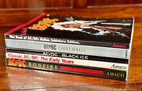 Stack of 4 AC/DC guitar tablature books showing titles and publisher Amsco