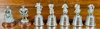 Five Sheffield pewter stirrup cups by Vogle showing figural tops lined up on a wooden base