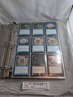 Single page of 9 blue and black Magic The Gathering cards from the 1998 Stronghold set in clear plastic sleeves, part of the card collection in a binder.