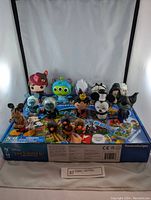 Wide view of the lot showing multiple Disney collectible figures displayed on top of a Ravensburger Hidden Picture board game box