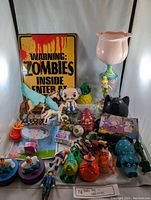 Photo of assorted kids toys and collectibles in a display including unicorns, figures, a zombie warning sign, and decorative items.
