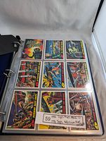 View of a plastic page sleeve showing colorful Mars Attacks trading cards from 1994 with sci-fi alien invasion scenes.