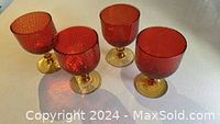 Photo showing four mid-century Italian glass goblets with red textured bowls and gold-colored stems and bases