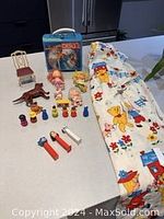 The full collection displayed on a white table including toys, lunch pail, Pez dispensers, curtain and small furniture items.