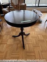 Full view showing round top and pedestal base with three legs