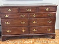 Front view of solid cherry wood 9-drawer dresser showing brass handles and wood grain.