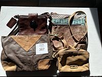 Four assorted purses arranged on a white surface showing variety in color and design.