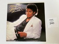 Front cover of Michael Jackson Thriller LP showing Michael Jackson in white jacket and black shirt.