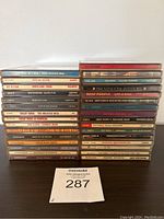 Photo showing front spines of assorted CDs stacked in two columns, names include Whitesnake, Cheap Trick, Supertramp, and The Clash among others.