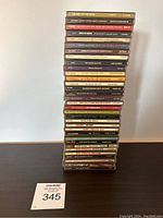 Photo of 32 CDs stacked one on top of another, showing spines with artist and album titles.