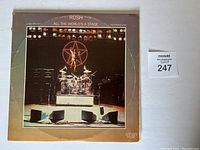 Front cover of Rush "All The World's A Stage" double vinyl album showing stage setup and band logo.