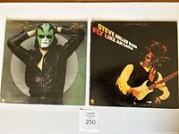Front covers of two Steve Miller Band LP vinyl albums The Joker (1973) and Fly Like An Eagle (1976). The Joker cover has Steve Miller wearing a green mask against a circular background. Fly Like An Eagle cover shows Steve Miller playing guitar on black background.