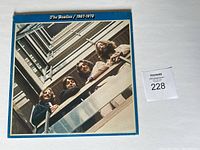 Front cover photo of the vinyl album showing the band members on a balcony looking down at the camera.
