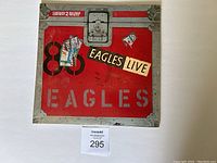 Front cover of The Eagles LIVE double album showing red road case design with stickers and band name