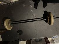 Barbell assembled with weight plates laid on puzzle-piece foam mat