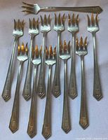 All twelve Alvin Richmond cocktail forks displayed