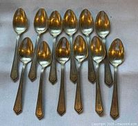 All twelve Alvin Sterling Richmond demitasse spoons laid out bowl up