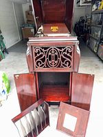 Full cabinet with lid open, turntable, front grille, storage compartment and detached knob shown