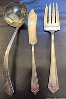 Ladle, serving fork and butter spreader displayed front view