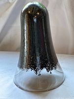 Full view of bell-shaped glass sculpture