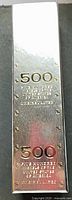 Exterior of silver reflective box showing "$500" and text