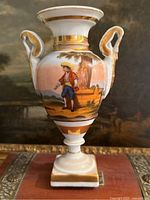 Front view of vase showing figural scene, handles, gilding