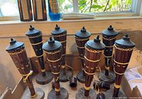 Eight bamboo tabletop tiki lamps standing in box