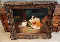 Full view of framed rabbit painting leaning against chest