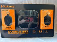 Front of retail package showing two speakers and case