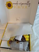 Open gift box showing blanket, tissue and interior branding