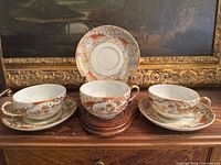 Front view of three cups with saucers and one saucer vertical for pattern display