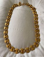Full view of linked gold-plated brass belt/necklace laid in oval form