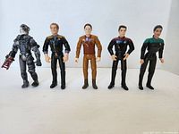 Front view of all five Star Trek action figures standing side by side showing different character uniforms and wear.