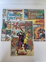 Photo showing three Fantastic Four comic books: #307, #335, and #336, arranged fanned out, with illustrated colorful covers depicting various superhero scenes and characters.