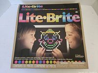 Photo of the Lite-Brite box showing branding and image of a lit clown peg art.