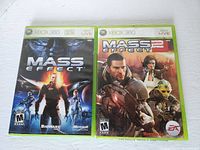 Two Xbox 360 game cases side by side: Mass Effect 1 on the left and Mass Effect 2 on the right, showing front cover art.