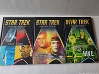 Front covers of 3 Star Trek graphic novels with distinct colorful artwork.