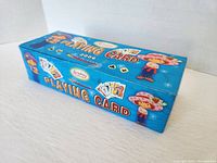 Photo showing the rectangular box packaging with colorful Strawberry Shortcake artwork and text 'Playing Card 2006'.