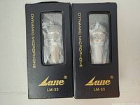 Two Lane LM-33 dynamic microphones in original boxes with plastic windows showing the microphones inside.