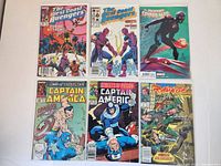 Photo showing 6 Marvel comic books: two The West Coast Avengers, one Spider-Man, two Captain America, and one Rawhide Kid. Covers are colorful but comics show wear and signs of age.