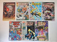 Photo showing seven DC Comics comic books including Genesis, two Checkmate! issues, Brain Banx, Captain Atom, and two Justice League issues.