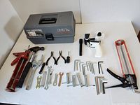Overview of all tools with toolbox showing various hand tools including grease gun, wrenches, pliers, and Allen keys