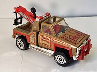 Front angled view showing gold and red paint, decals, and tow hook assembly on back.