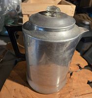 Photo showing full view of the aluminum coffee percolator with black handle and lid knob.