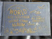Front cover of the stamp album showing gray cloth with gold embossed text and illustrations including a globe and cityscape
