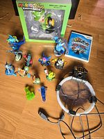Full lot showing multiple small Skylanders figurines, Wii game case, Rabid Luigi boxed figurine, and Portal of Power accessory with cable.