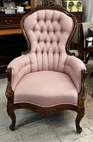 Full front view of pink upholstered Victorian armchair on hardwood carved frame