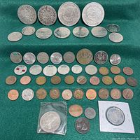 Top down photo showing various arranged coins including larger Canadian dollars and smaller cents in rows on green background.