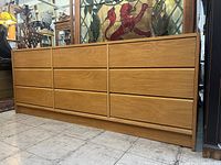 Front view of the Mid-Century Modern oak dresser showing all 9 drawers and its clean minimal design.